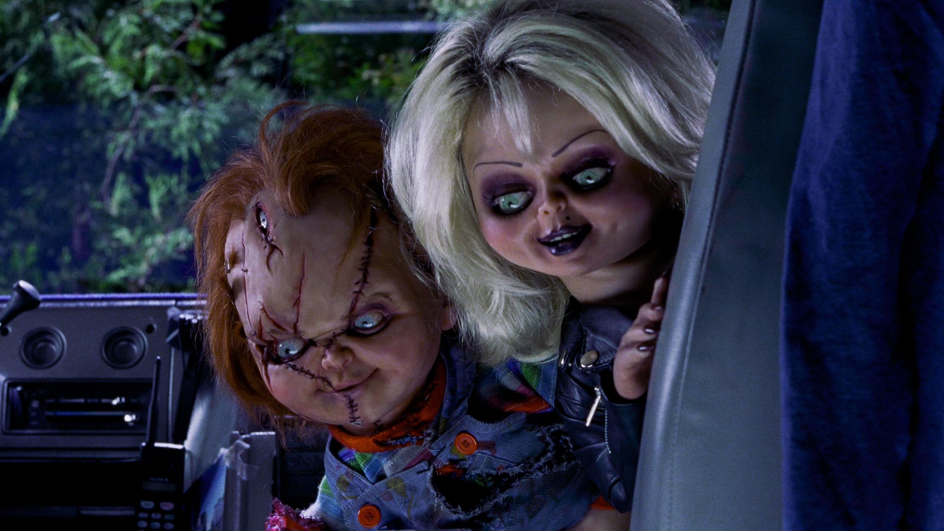 Cinematic background from Bride of Chucky 1998 - After being cut apart by the police, killer doll Chucky is resurrected by Tiffany, an ex-girlfriend of the serial murderer whose soul is inside the toy. Following an argument, Chucky kills Tiffany and transfers her soul into a bride doll. To find the magical amulet that can restore them both to human form, Chucky and Tiffany arrange to be driven to New Jersey by Jesse and Jade, who are unaware that their cargo is alive.
