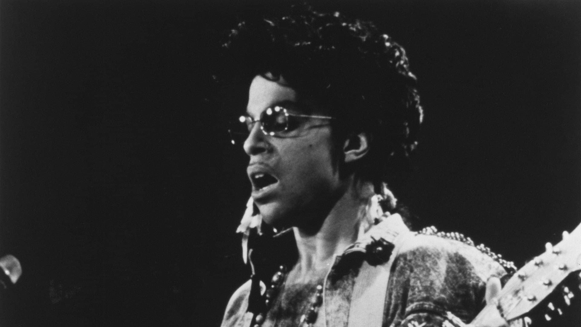 Cinematic background from Sign 'o' the Times 1987 - In 1987, to capitalize on his growing success in Europe, Prince toured extensively to promote the album of the same name and sales increased accordingly. However, the United States remained resistant to his latest album, and sales began to drop; it was at this point that Prince decided to film a live concert promoting the new material, for eventual distribution to theaters in America.  Featuring the band that accompanied Prince on his 1987 Sign o' the Times Tour, including dancer Cat Glover, keyboardist Boni Boyer, bassist Levi Seacer, Jr., guitarist Miko Weaver, drummer Sheila E. and former member of The Revolution keyboardist Dr. Fink, the film sees the group perform live on stage (although "U Got the Look" is represented by its promotional music video).
