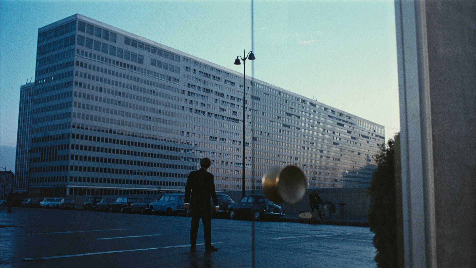 Cinematic background from Playtime 1967 - Clumsy Monsieur Hulot finds himself perplexed by the intimidating complexity of a gadget-filled Paris. He attempts to meet with a business contact but soon becomes lost. His roundabout journey parallels that of an American tourist, and as they weave through the inventive urban environment, they intermittently meet, developing an interest in one another. They eventually get together at a chaotic restaurant, along with several other quirky characters.