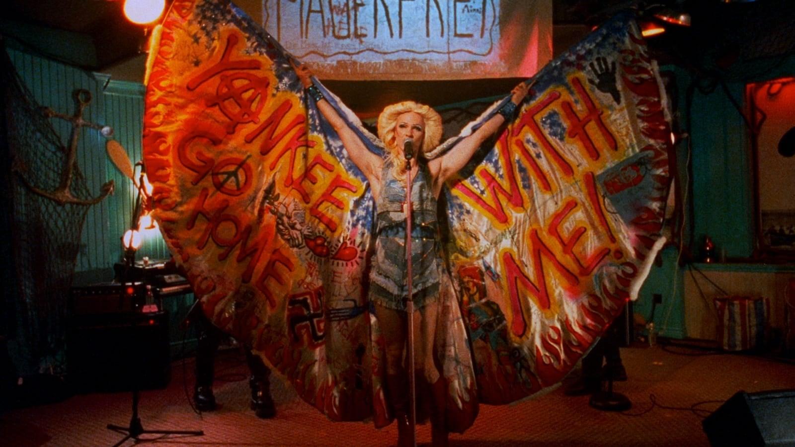 Cinematic background from Hedwig and the Angry Inch 2001 - Raised a boy in East Berlin, Hedwig undergoes a personal transformation in order to emigrate to the U.S., where she reinvents herself as an “internationally ignored” but divinely talented rock diva, inhabiting a “beautiful gender of one.”
