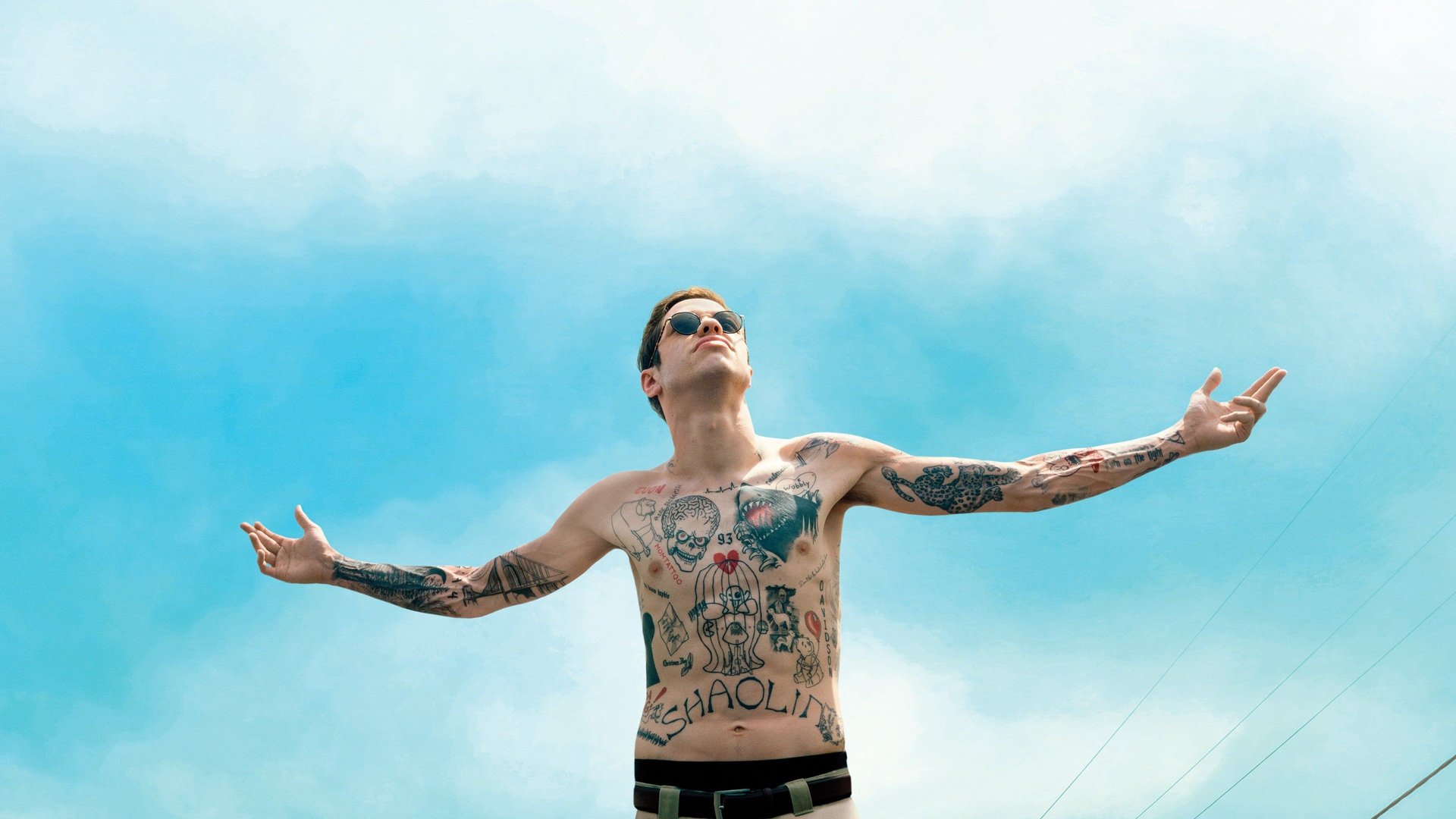 Cinematic background from The King of Staten Island 2020 - Scott has been a case of arrested development ever since his firefighter father died when he was seven. He's now reached his mid-20s having achieved little, chasing a dream of becoming a tattoo artist that seems far out of reach. As his ambitious younger sister heads off to college, Scott is still living with his exhausted ER nurse mother and spends his days smoking weed, hanging with the guys — Oscar, Igor and Richie — and secretly hooking up with his childhood friend Kelsey. But when his mother starts dating a loudmouth firefighter named Ray, it sets off a chain of events that will force Scott to grapple with his grief and take his first tentative steps toward moving forward in life.