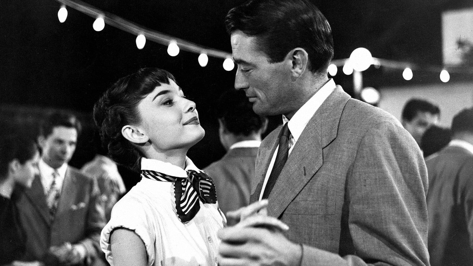 Cinematic background from Roman Holiday 1953 - Overwhelmed by her suffocating schedule, touring European princess Ann takes off for a night while in Rome. When a sedative she took from her doctor kicks in, however, she falls asleep on a park bench and is found by an American reporter, Joe Bradley, who takes her back to his apartment for safety. At work the next morning, Joe finds out Ann's regal identity and bets his editor he can get exclusive interview with her, but romance soon gets in the way.