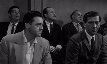 Movie still from “12 Angry Men” (1957), directed by Sidney Lumet – A black and white photo of a group of men sitting; Medium shot, Low angle
