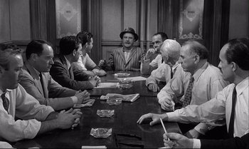 Movie still from “12 Angry Men” (1957), directed by Sidney Lumet – A group of people sitting around a table; Medium shot, Over the shoulder angle