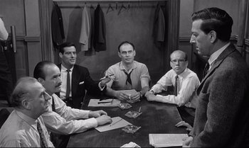 Movie still from “12 Angry Men” (1957), directed by Sidney Lumet – A black and white photo of a group of men sitting at a table; Medium shot, Over the shoulder angle