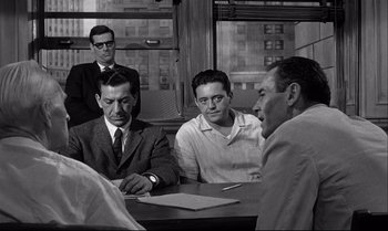 Movie still from “12 Angry Men” (1957), directed by Sidney Lumet – A group of men sitting around a table; Medium shot, Over the shoulder angle
