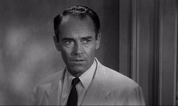 Movie still from “12 Angry Men” (1957), directed by Sidney Lumet – A man wearing a suit and tie in a black and white photo; Close Up shot, Over the shoulder angle