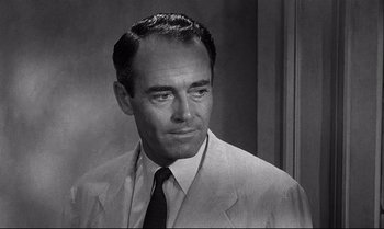 Movie still from “12 Angry Men” (1957), directed by Sidney Lumet – A man in a suit and tie looking to his left; Close Up shot, Over the shoulder angle