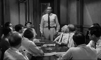 Movie still from “12 Angry Men” (1957), directed by Sidney Lumet – A group of people sitting around a table; Medium shot, Over the shoulder angle