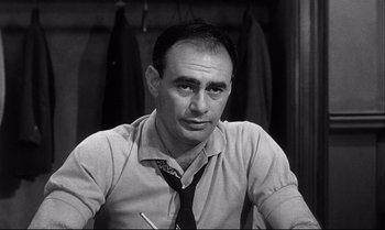 Movie still from “12 Angry Men” (1957), directed by Sidney Lumet – A man in a tie sitting in front of a wall; Close Up shot, Low angle