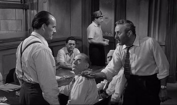 Movie still from “12 Angry Men” (1957), directed by Sidney Lumet – A group of men standing in a room; Medium shot, Over the shoulder angle