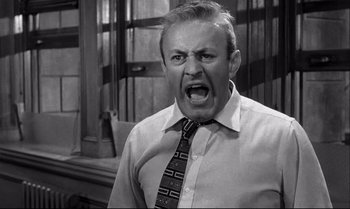 Movie still from “12 Angry Men” (1957), directed by Sidney Lumet – An older man wearing a neck tie and a white dress shirt; Close Up shot, Low angle