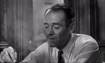 Movie still from “12 Angry Men” (1957), directed by Sidney Lumet – An old black and white photo of a man in a dress shirt and tie; Close Up shot, High angle