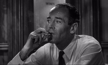 Movie still from “12 Angry Men” (1957), directed by Sidney Lumet – A man smoking a cigarette while wearing a tie; Close Up shot, Low angle