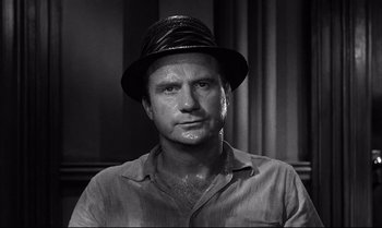 Movie still from “12 Angry Men” (1957), directed by Sidney Lumet – Black and white photograph of a man wearing a hat; Close Up shot, Low angle