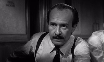 Movie still from “12 Angry Men” (1957), directed by Sidney Lumet – An older man with a mustache wearing a tie and suspenders; Close Up shot, Low angle