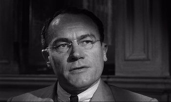 Movie still from “12 Angry Men” (1957), directed by Sidney Lumet – An older man wearing glasses and a suit; Close Up shot, Low angle
