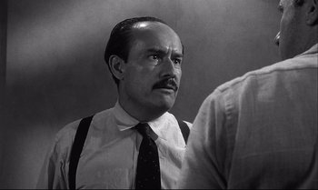 Movie still from “12 Angry Men” (1957), directed by Sidney Lumet – A man with a mustache wearing a tie and suspenders; Close Up shot, Over the shoulder angle