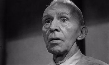 Movie still from “12 Angry Men” (1957), directed by Sidney Lumet – An old man with a bald head and a mustache; Close Up shot, Low angle