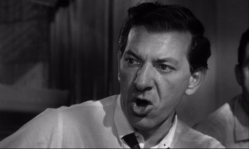 Movie still from “12 Angry Men” (1957), directed by Sidney Lumet – A man in a white dress shirt and a black tie; Close Up shot, High angle