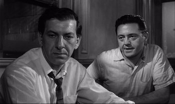 Movie still from “12 Angry Men” (1957), directed by Sidney Lumet – A black and white photo of two men sitting at a table; Close Up shot, Over the shoulder angle