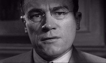 Movie still from “12 Angry Men” (1957), directed by Sidney Lumet – Black and white photograph of a man wearing glasses; Close Up shot, Low angle