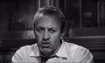 Movie still from “12 Angry Men” (1957), directed by Sidney Lumet – A man with a tie is making an angry face; Close Up shot, Low angle