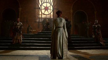 Movie still from “Game of Thrones” (2011), created by D.B. Weiss – A woman dressed in medieval clothing stands in front of a window; Wide shot, Low angle