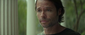 Movie still from “Hateship Loveship” (2013), directed by Liza Johnson – A man's face looking at the camera; Close Up shot, Over the shoulder angle