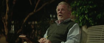 Movie still from “Hateship Loveship” (2013), directed by Liza Johnson – An older man sitting in front of a microphone; Medium shot, Over the shoulder angle