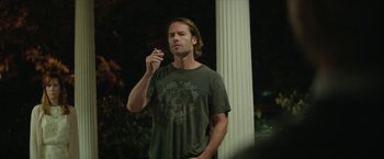 Movie still from “Hateship Loveship” (2013), directed by Liza Johnson – A man standing in front of a white pillar; Medium shot, Over the shoulder angle