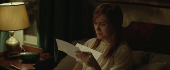 Movie still from “Hateship Loveship” (2013), directed by Liza Johnson – A woman sitting on a couch looking at a piece of paper; Close Up shot, Over the shoulder angle