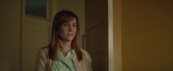 Movie still from “Hateship Loveship” (2013), directed by Liza Johnson – A woman standing in front of a door looking at the camera; Close Up shot, Over the shoulder angle