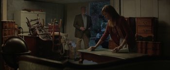 Movie still from “Hateship Loveship” (2013), directed by Liza Johnson – A woman and a man are standing in a living room; Medium shot, Over the shoulder angle