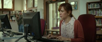 Movie still from “Hateship Loveship” (2013), directed by Liza Johnson – A woman sitting in front of a computer keyboard; Medium shot, Over the shoulder angle