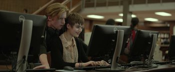 Movie still from “Hateship Loveship” (2013), directed by Liza Johnson – A man and a woman working on a computer; Medium shot, Low angle