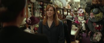 Movie still from “Hateship Loveship” (2013), directed by Liza Johnson – A woman standing in front of a bunch of hats; Close Up shot, Over the shoulder angle