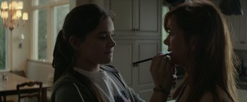 Movie still from “Hateship Loveship” (2013), directed by Liza Johnson – A young woman is putting makeup on another young woman's face; Close Up shot, Over the shoulder angle