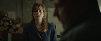 Movie still from “Hateship Loveship” (2013), directed by Liza Johnson – A red headed woman stares at a man in a suit; Close Up shot, Over the shoulder angle