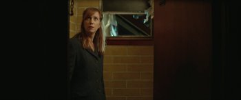 Movie still from “Hateship Loveship” (2013), directed by Liza Johnson – A woman standing in front of a brick wall looking to her left; Medium shot, Over the shoulder angle