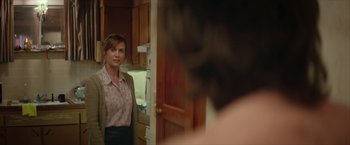 Movie still from “Hateship Loveship” (2013), directed by Liza Johnson – A woman standing in a kitchen looking into a mirror; Medium shot, Over the shoulder angle