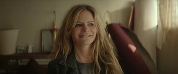 Movie still from “Hateship Loveship” (2013), directed by Liza Johnson – A person with long hair smiling; Close Up shot, Over the shoulder angle