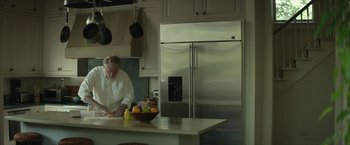 Movie still from “Hateship Loveship” (2013), directed by Liza Johnson – A man standing in front of a kitchen counter; Medium shot, Low angle