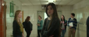 Movie still from “Hateship Loveship” (2013), directed by Liza Johnson – A young woman standing in a room with other women; Medium shot, Over the shoulder angle