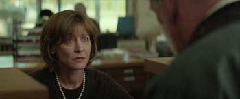 Movie still from “Hateship Loveship” (2013), directed by Liza Johnson – An older woman sitting in front of a man in an office setting; Close Up shot, Over the shoulder angle