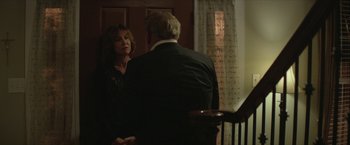 Movie still from “Hateship Loveship” (2013), directed by Liza Johnson – A man and a woman standing next to each other in a room; Medium shot, Over the shoulder angle