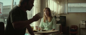 Movie still from “Hateship Loveship” (2013), directed by Liza Johnson – A woman sitting at a table with a man; Medium shot, Over the shoulder angle