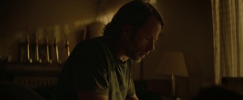 Movie still from “Hateship Loveship” (2013), directed by Liza Johnson – A person sitting in a room; Close Up shot, Over the shoulder angle