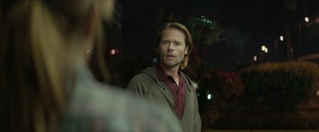 Movie still from “Hateship Loveship” (2013), directed by Liza Johnson – A man standing in front of another man in the dark; Close Up shot, Over the shoulder angle