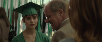 Movie still from “Hateship Loveship” (2013), directed by Liza Johnson – A man and a woman in a cap and gown talking to each other; Close Up shot, Over the shoulder angle